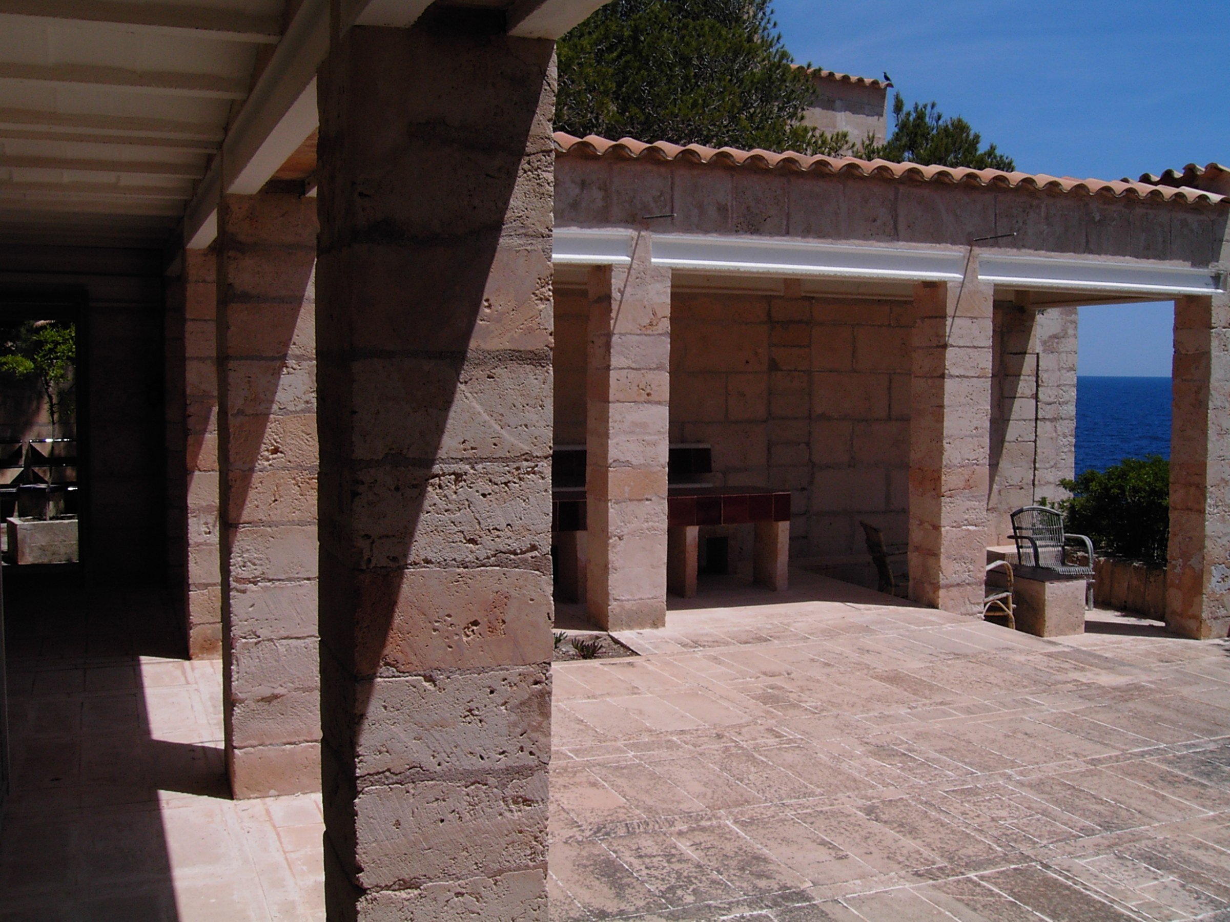 Porche profundo de piedra en Can Lis, de Jørn Utzon, que da sombra a la vivienda