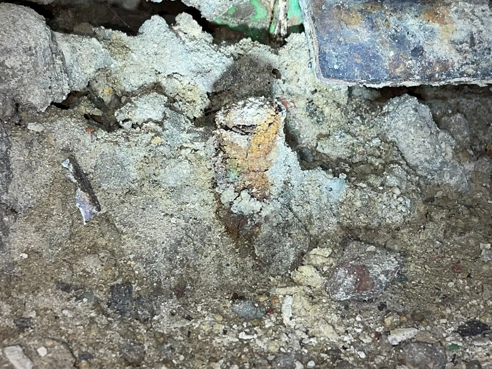 Perno de anclaje completamente corroído entre restos de hormigón