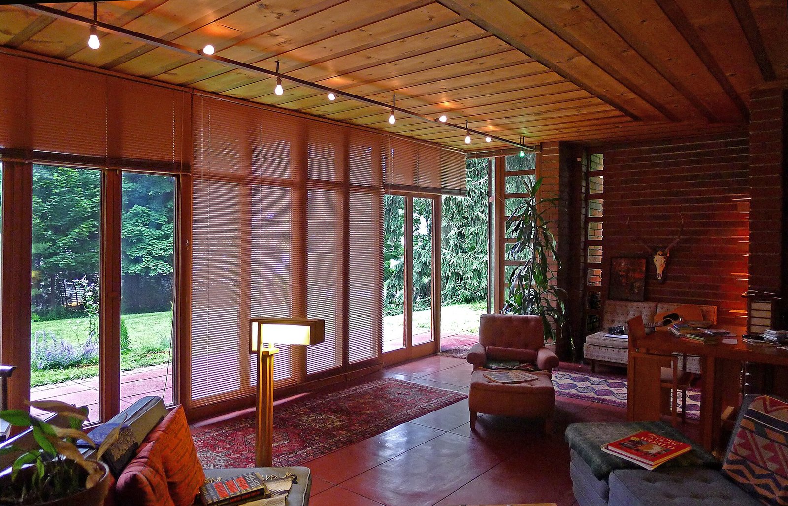 Salón de la casa Jacobs de Frank Lloyd Wright, con madera y puertas de vidrio al jardín