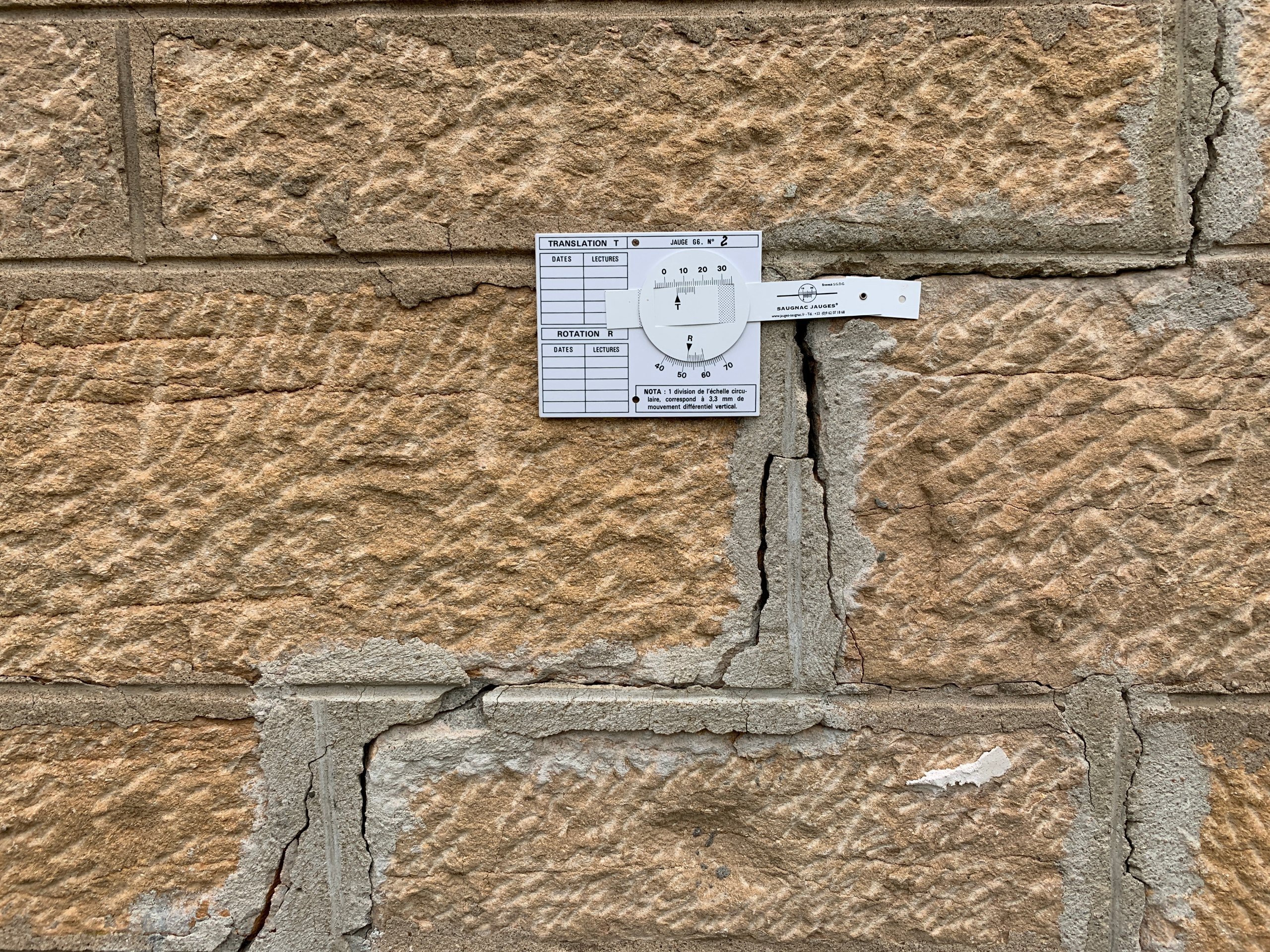 Grieta en un muro de sillería con un testigo de seguimiento