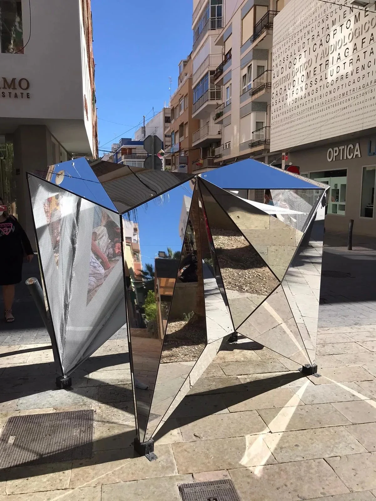 Detalle de la instalación Reflejo con el cielo y los edificios reflejados en los paneles espejo