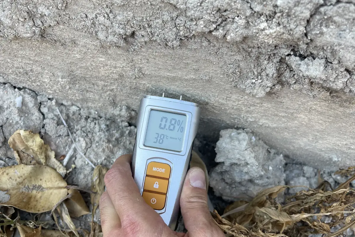 Medidor de humedad apoyado en la base de una pared