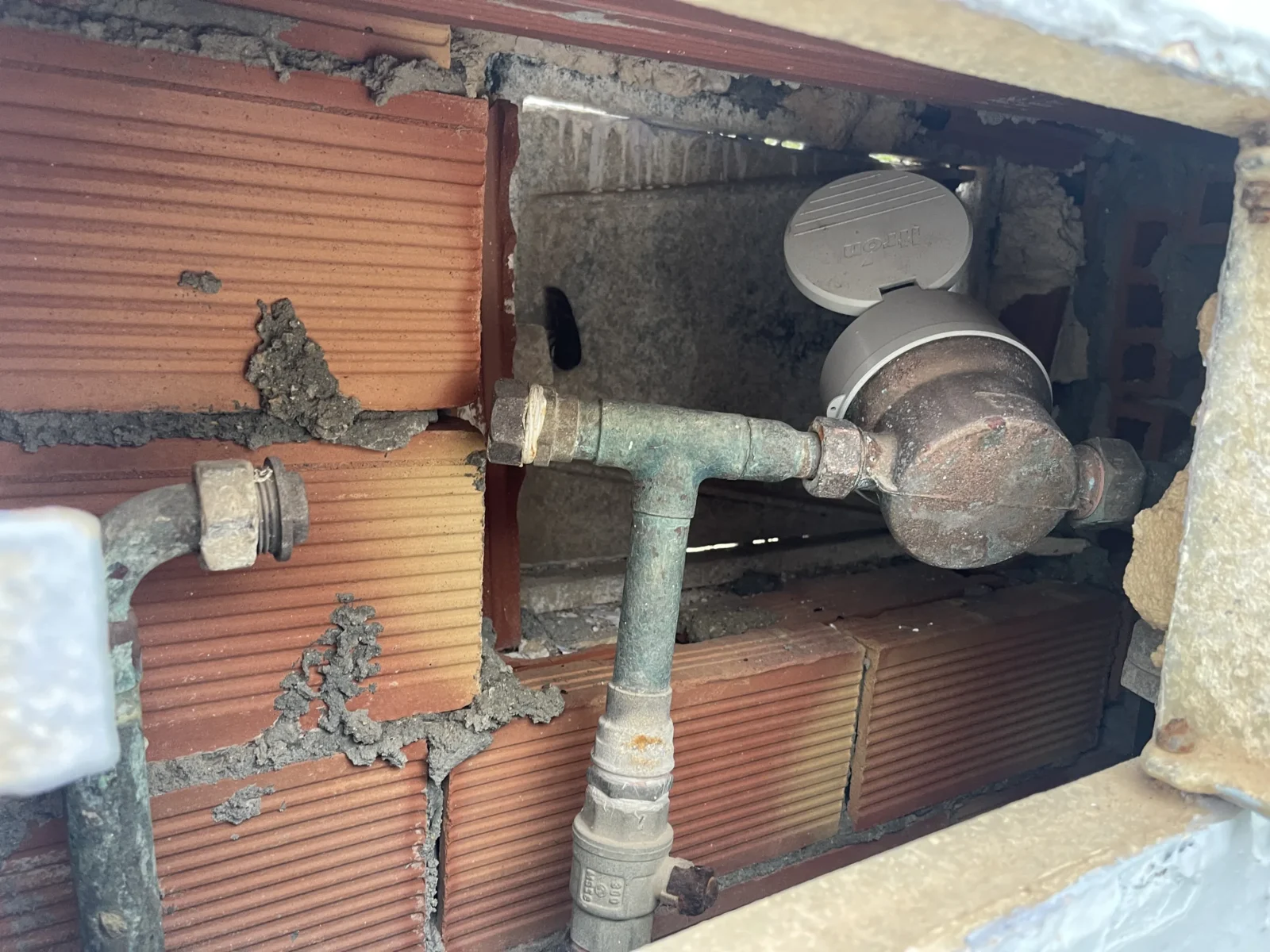 Contador de agua antiguo en el muro